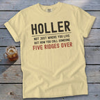 Yellow t-shirt with black text: "HOLLER NOT JUST WHERE YOU LIVE BUT HOW YOU CALL SOMEONE FIVE RIDGES OVER".