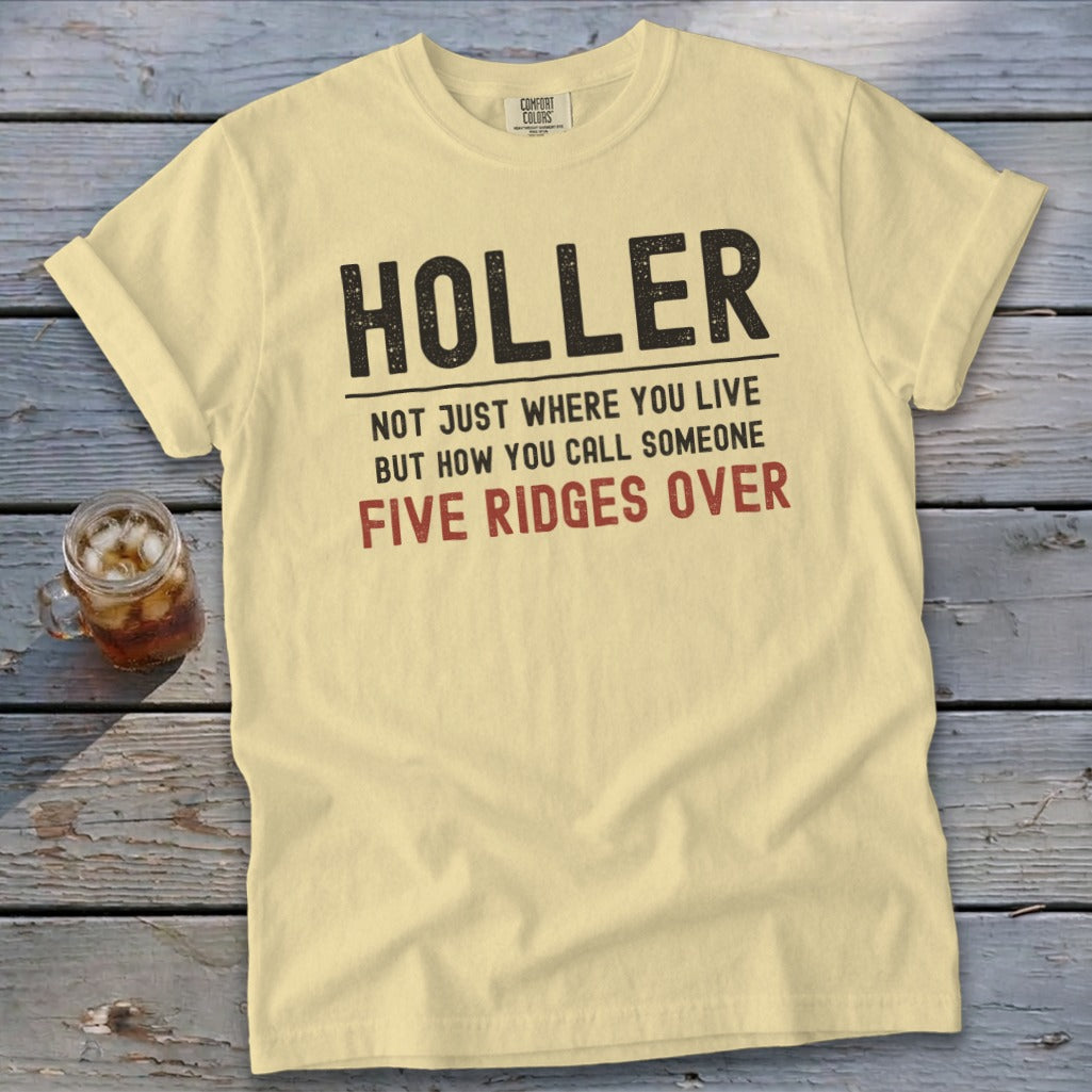 Yellow t-shirt with black text: "HOLLER NOT JUST WHERE YOU LIVE BUT HOW YOU CALL SOMEONE FIVE RIDGES OVER".