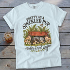 White t-shirt with "Pretty As A Speckled Pup Under A Red Wagon" text and sleeping dog design.