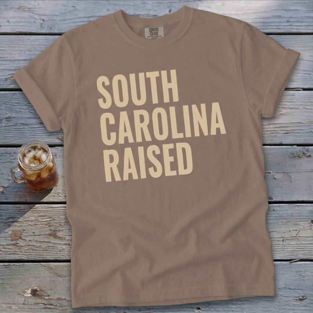 T-shirt with "South Carolina Raised" text in a tan color.