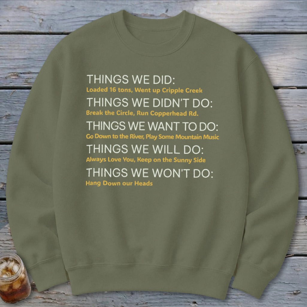 Olive green sweatshirt with white and yellow text listing "Things We Did".