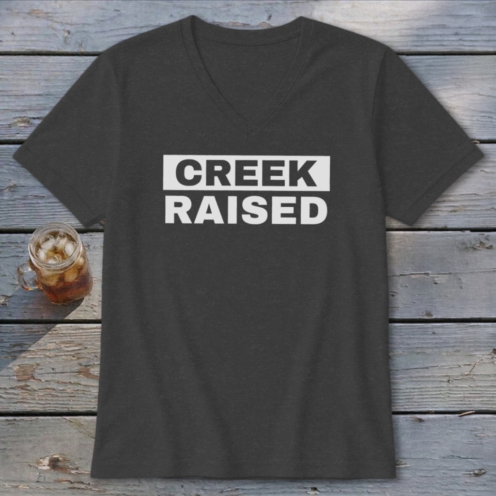 Dark grey v-neck t-shirt with white text "CREEK RAISED" on the chest.