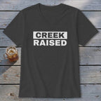 Dark grey v-neck t-shirt with white text "CREEK RAISED" on the chest.