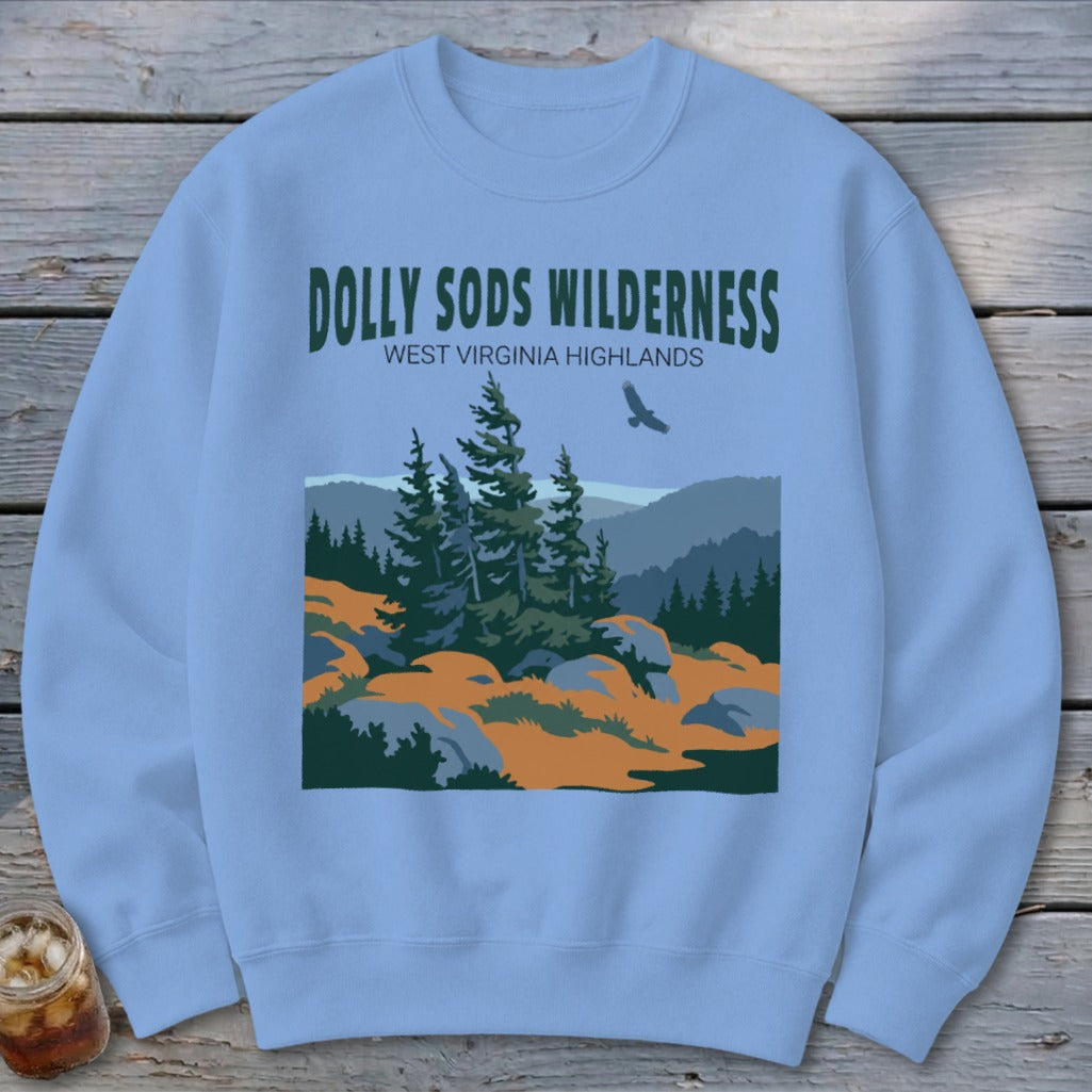 A light blue crewneck sweatshirt featuring a graphic of Dolly Sods Wilderness with mountains, pine trees, and a flying bird.