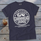 Dark blue crewneck t-shirt with white graphic text reading Certified Cornbread Judge and a cornbread illustration.