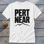 White t-shirt with bold black text reading PERT NEAR above a mountain outline graphic.