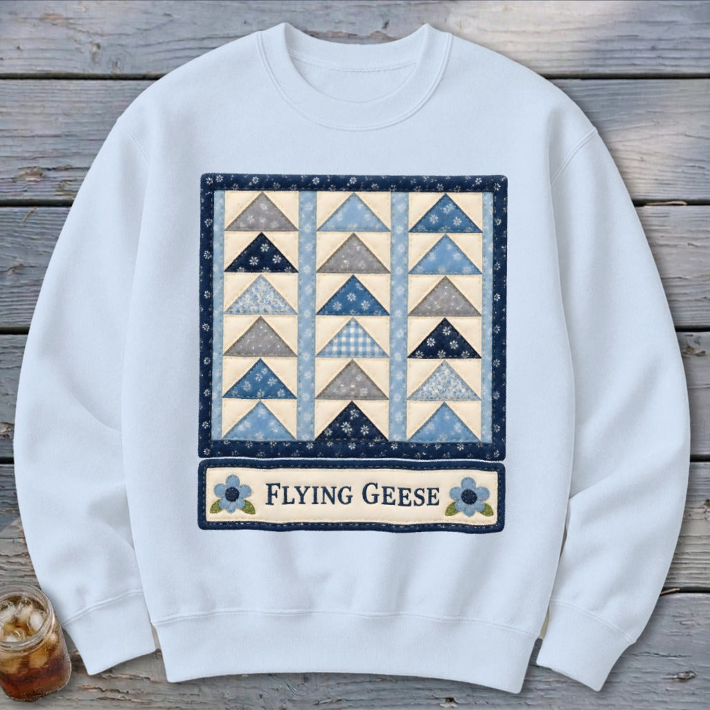 Light blue sweatshirt with a "Flying Geese" quilt design in blue, gray, and cream.