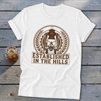White t-shirt with brown lantern graphic and "Established in the Hills" text.