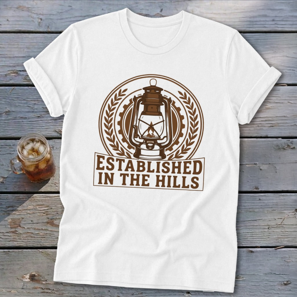 White t-shirt with brown lantern graphic and "Established in the Hills" text.