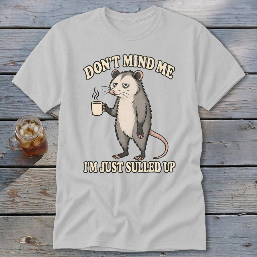 Opossum holding a coffee cup with text "Don't mind me, I'm just sulled up".