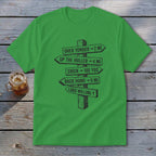 A green short-sleeved t-shirt features a black graphic of a rustic wooden signpost pointing in various directions with humorous text.