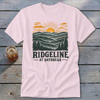 Pink t-shirt with "RIDGELINE AT DAYBREAK" text and mountain sunset graphic.