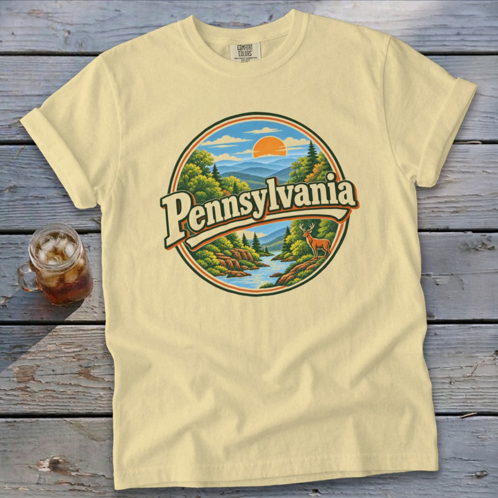 Pale yellow t-shirt with circular Pennsylvania landscape graphic featuring deer and river.