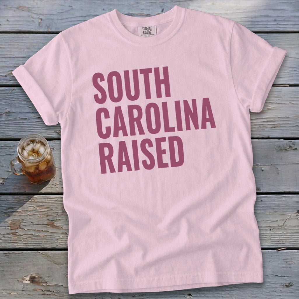 Pink t-shirt with "SOUTH CAROLINA RAISED" in maroon text.