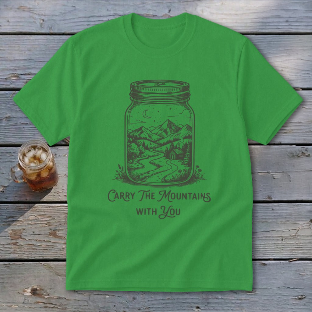 Bright green t-shirt with a graphic of a mountain landscape in a jar and text reading Carry The Mountains With You.