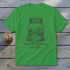 Bright green t-shirt with a graphic of a mountain landscape in a jar and text reading Carry The Mountains With You.
