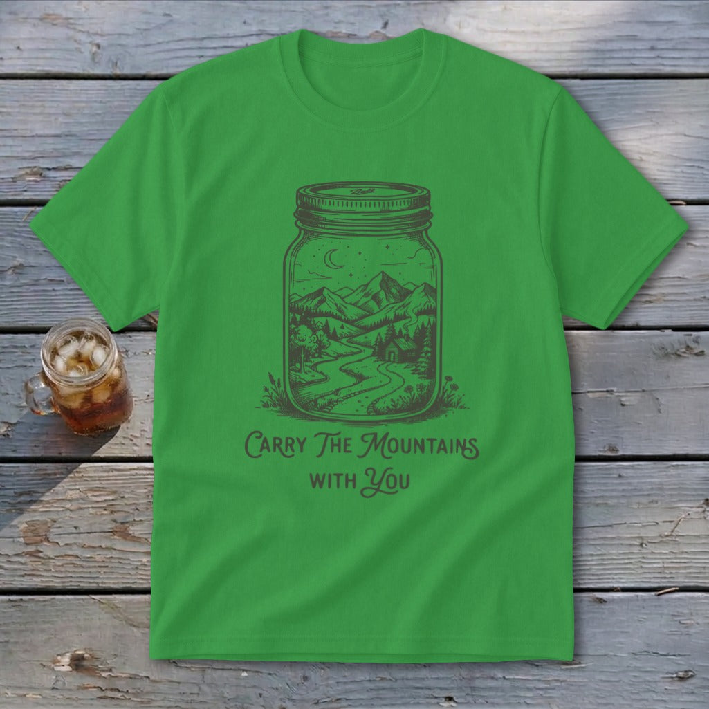 Bright green t-shirt with a graphic of a mountain landscape in a jar and text reading Carry The Mountains With You.