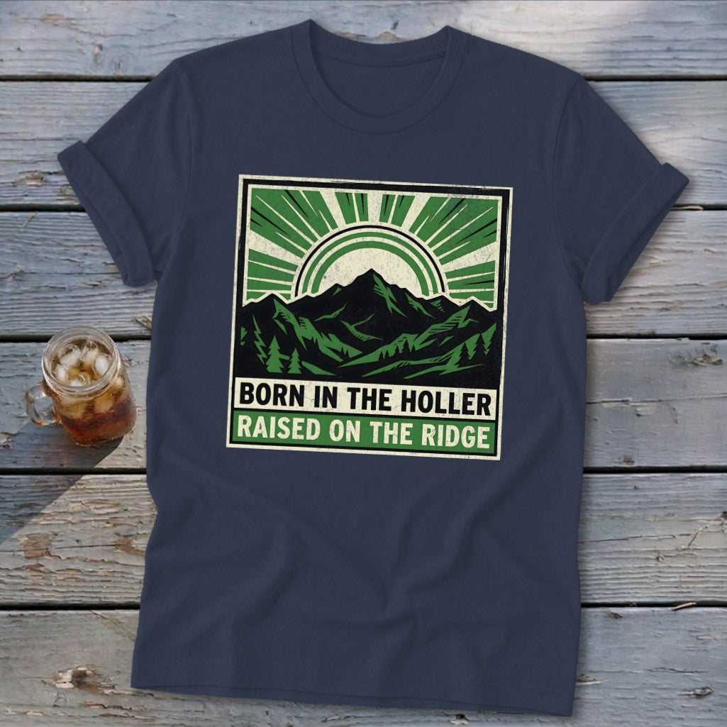 Dark blue t-shirt with a green graphic featuring mountains and the text "BORN IN THE HOLLER RAISED ON THE RIDGE".