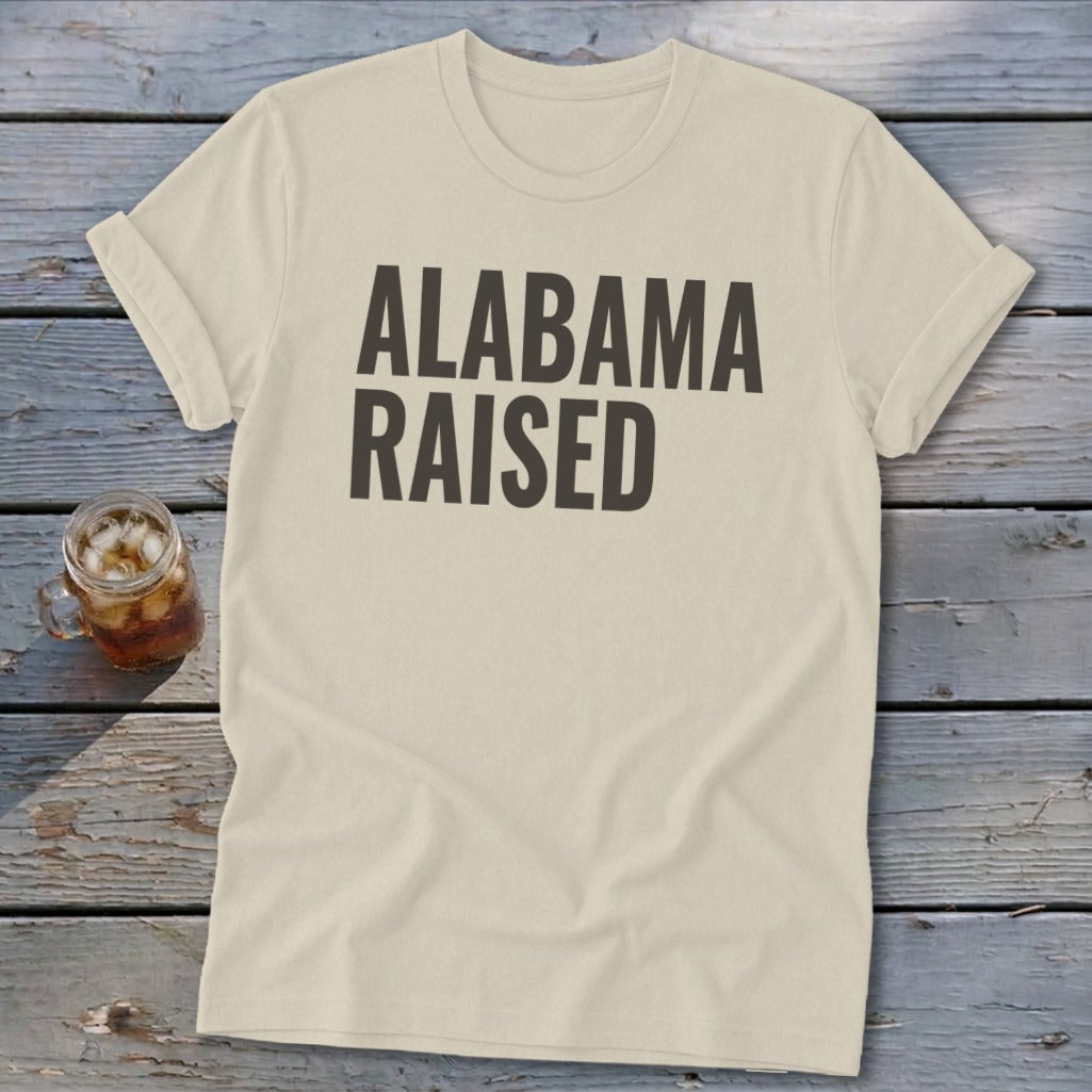 Cream t-shirt with "ALABAMA RAISED" in dark gray text.