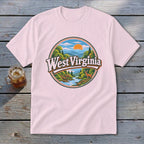 Pink t-shirt with circular West Virginia landscape featuring deer and river.