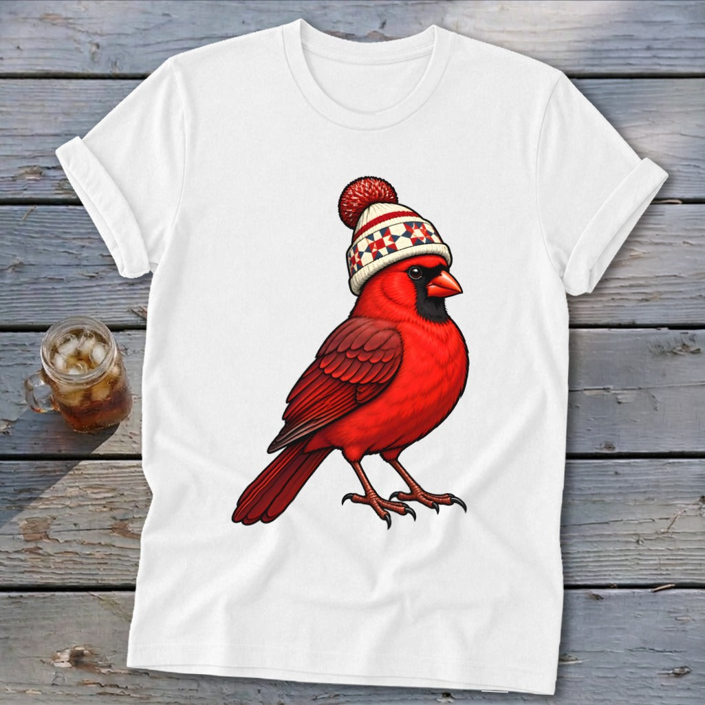 A white t-shirt featuring a graphic of a red cardinal wearing a winter beanie with a pom-pom.