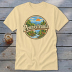 Cream t-shirt with circular Pennsylvania mountain landscape graphic and deer.
