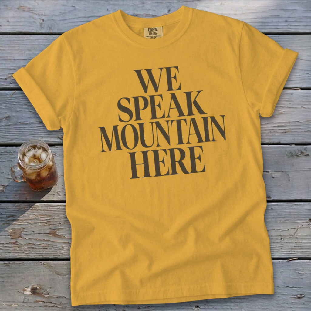 Yellow t-shirt with dark gray text that reads "WE SPEAK MOUNTAIN HERE".