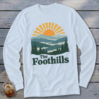 White long-sleeve shirt with "The Foothills" and mountain sunset graphic.