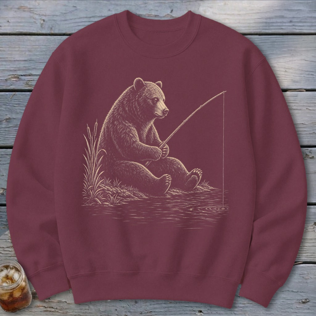 Bear fishing with rod and reel on water's edge with reeds.