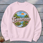 Pink sweatshirt with circular Tennessee landscape graphic featuring mountains, river, deer, and sunset.
