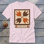 Pink t-shirt with a "Turkey Track" quilt block design and autumn floral accents.