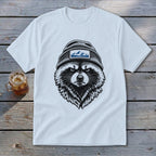 White t-shirt with a black and white illustration of a raccoon wearing a beanie with mountains.