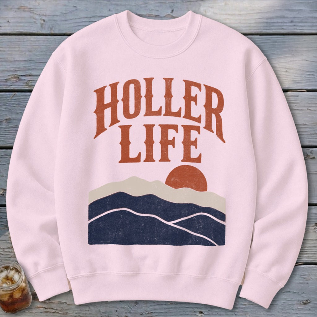 Light pink crewneck sweatshirt featuring the text HOLLER LIFE above a sunset mountain graphic.