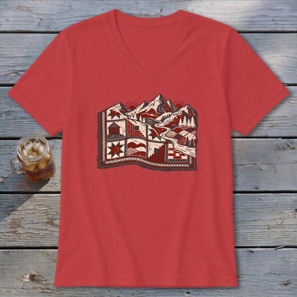 Red V-neck t-shirt featuring a graphic print of a patchwork quilt landscape with mountains.