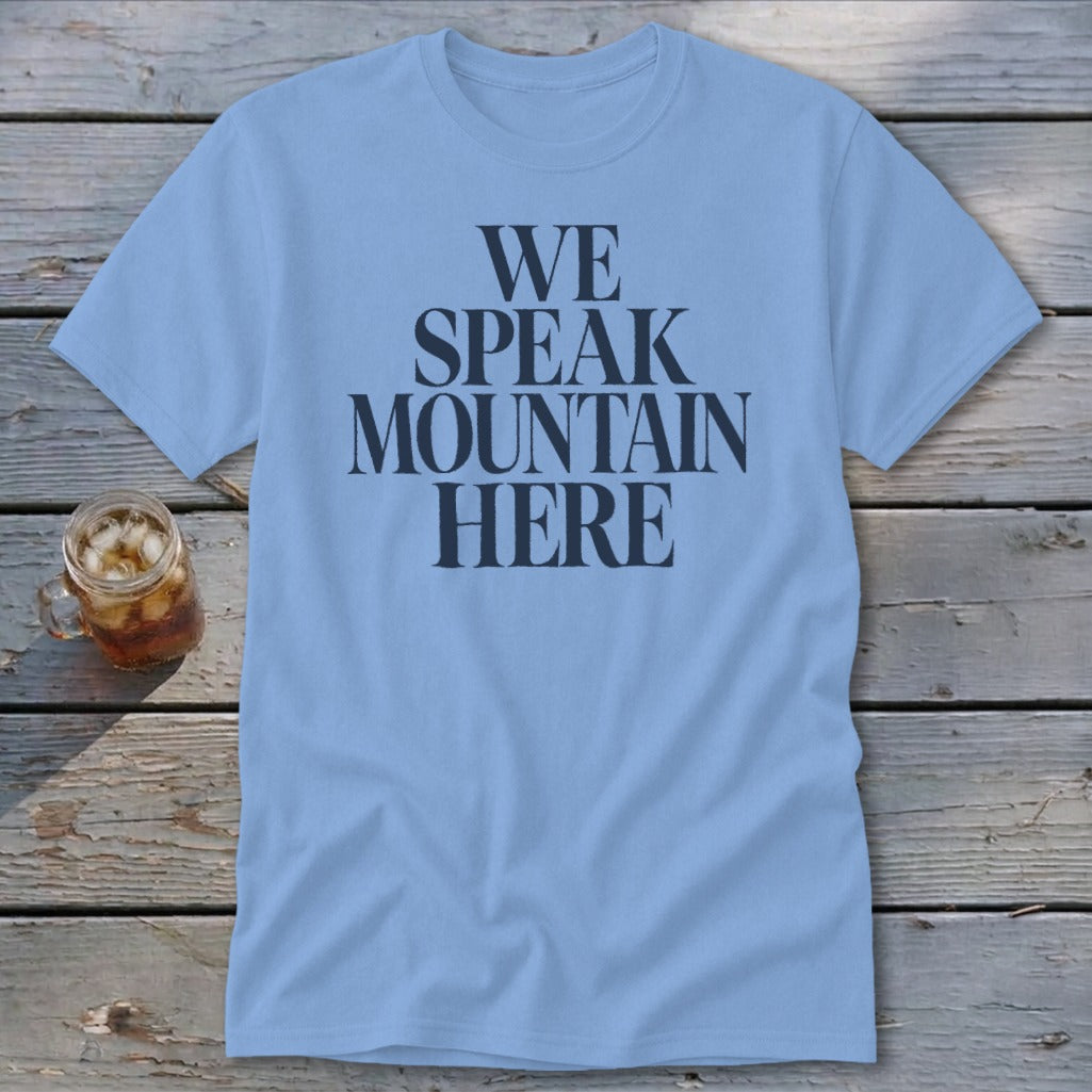 Light blue t-shirt with "WE SPEAK MOUNTAIN HERE" in dark grey text.