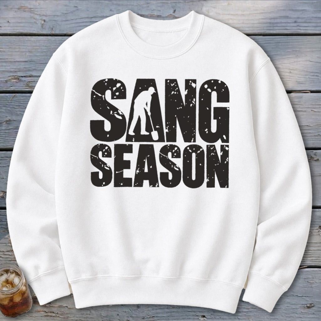 White crewneck sweatshirt with bold, distressed black text reading SANG SEASON and a silhouette of a person digging.