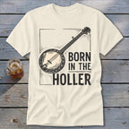 Cream t-shirt with banjo graphic and text "BORN IN THE HOLLER".