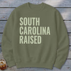 Olive green sweatshirt with "SOUTH CAROLINA RAISED" text.