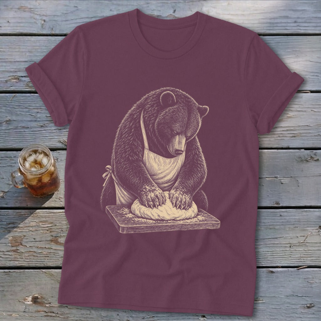 Bear wearing an apron kneading dough on a cutting board.