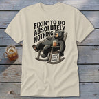 Cream t-shirt featuring a graphic of a bear lounging in a rocking chair with text reading "Fixin' to do absolutely nothing".
