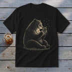 Black t-shirt with a drawing of a bear holding a jar of fireflies.