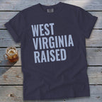 Dark t-shirt with "WEST VIRGINIA RAISED" text in light blue.