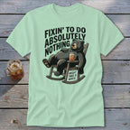 A light green t-shirt with a cartoon bear relaxing in a rocking chair with a drink.