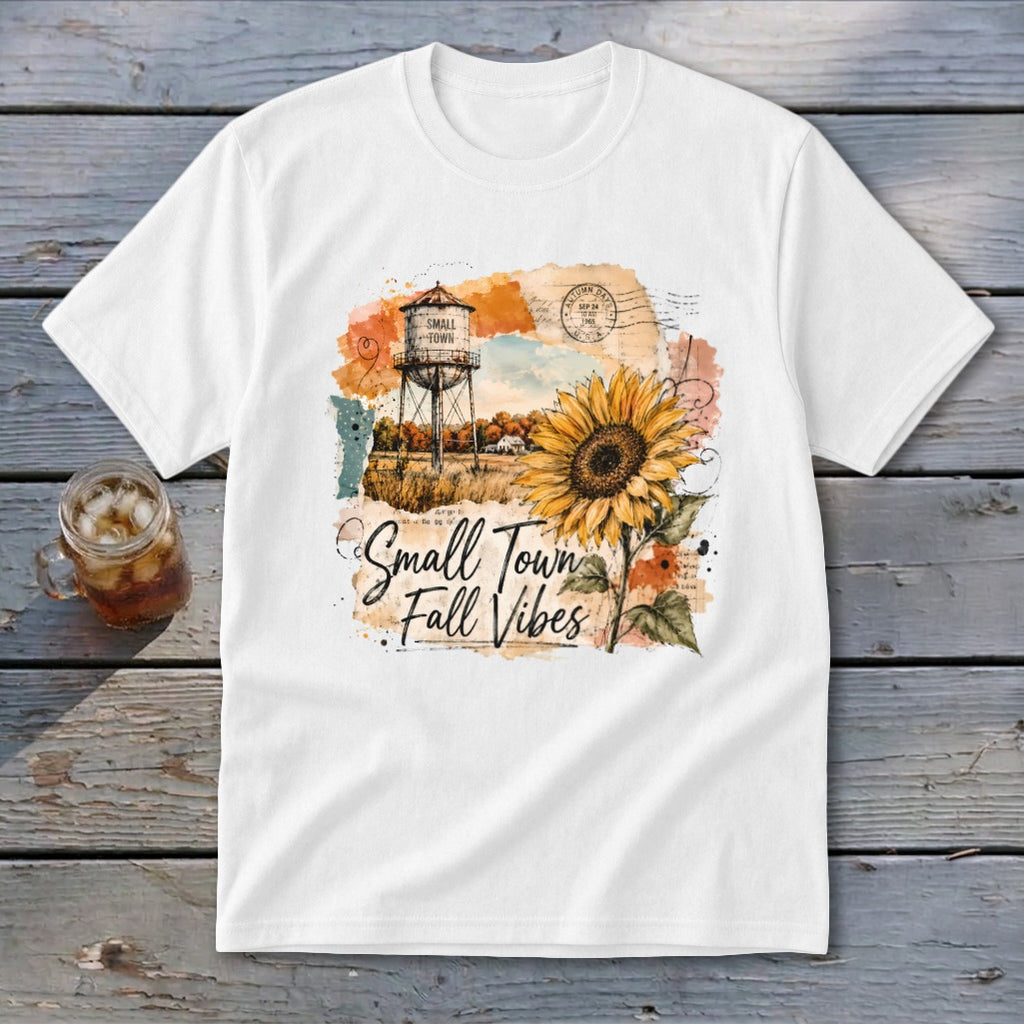 White t-shirt graphic with water tower, sunflower, and "Small Town Fall Vibes" text.