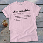 Light pink t-shirt featuring dictionary-style text defining Appalachia, laid flat on a rustic wooden surface.