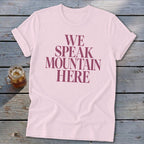 Pink t-shirt with "WE SPEAK MOUNTAIN HERE" text and a glass of iced tea.