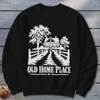 Black sweatshirt with white graphic of a farmhouse, trees, and the text "OLD HOME PLACE".