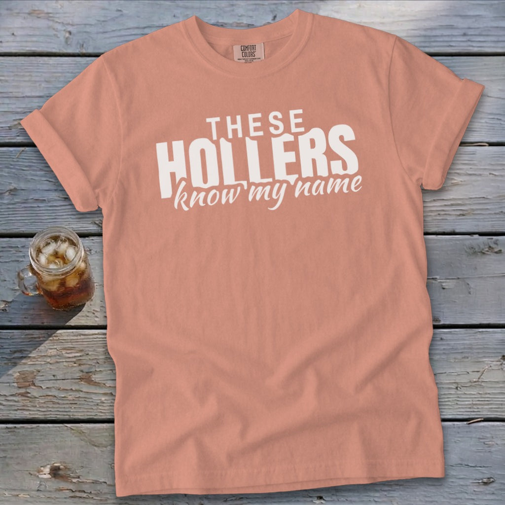Peach t-shirt with white text that reads "THESE HOLLERS know my name."