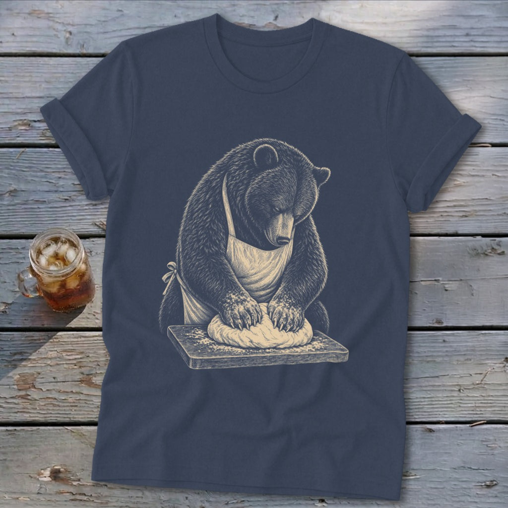 Bear wearing apron kneading dough on a wooden cutting board graphic on a t-shirt.
