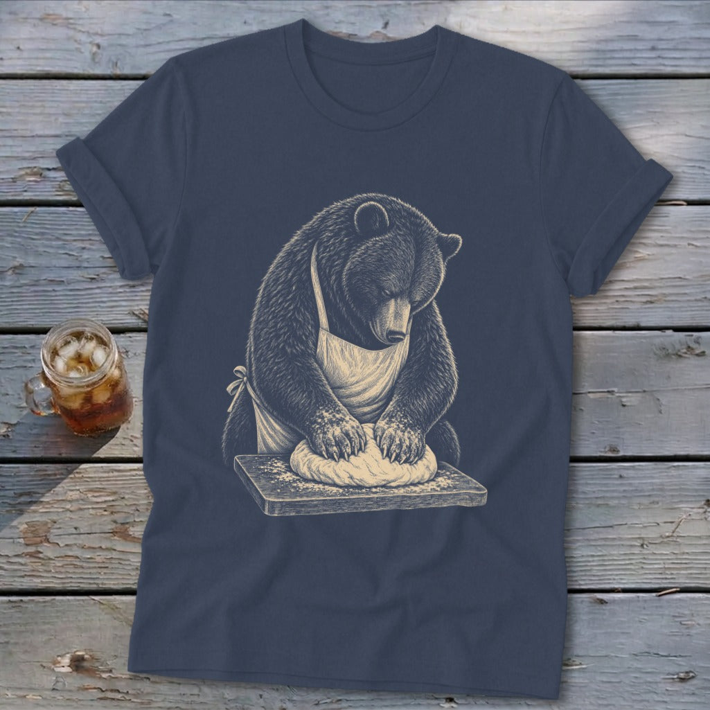 Bear wearing apron kneading dough on a wooden cutting board graphic on a t-shirt.